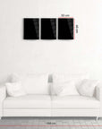 Stylish Atatürk 3'lü set cam tablo displayed above a modern white sofa in a minimalist living room.