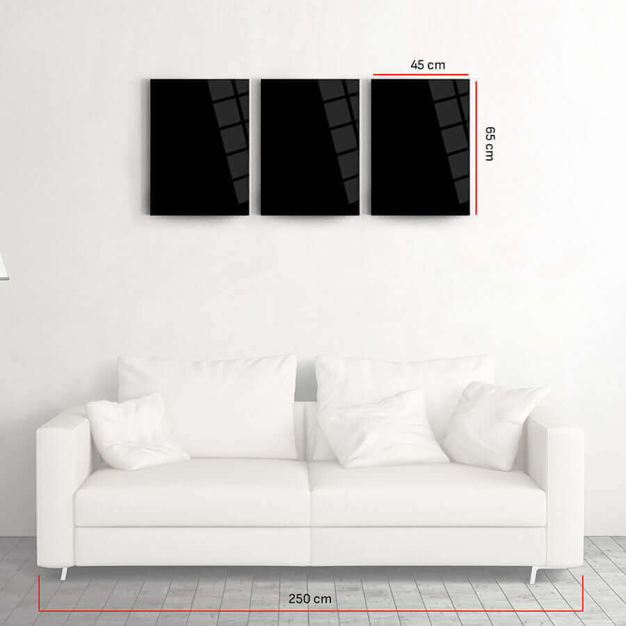 Minimalist black glass wall art set above a modern white sofa, featuring three panels size 45x65 cm.