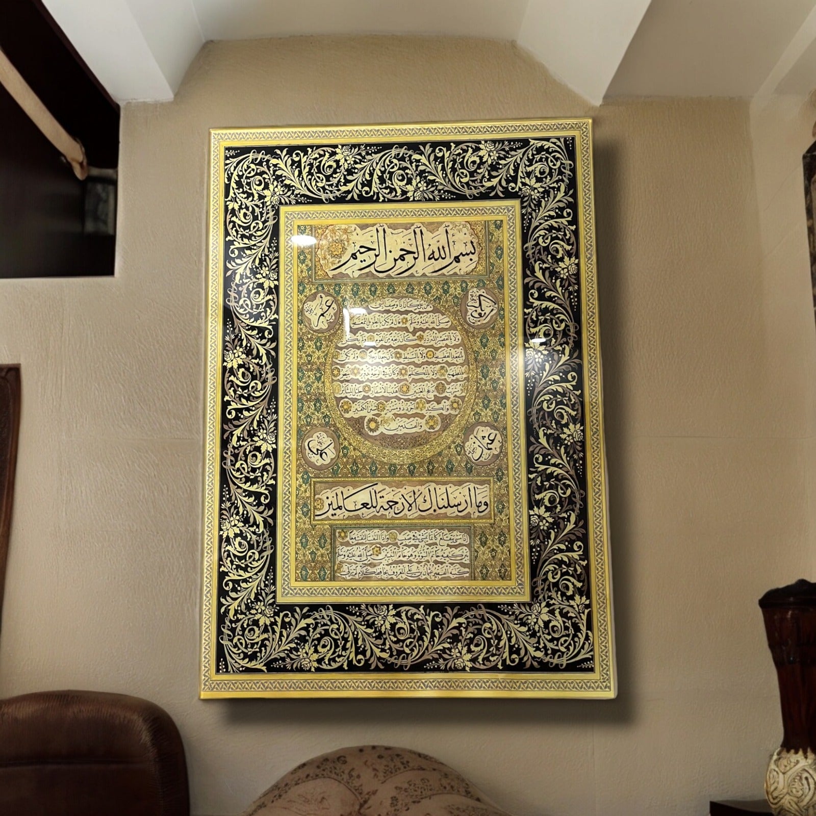 Hilye-i Şerif glass artwork with intricate gold and black designs, showcasing Islamic calligraphy on the wall.