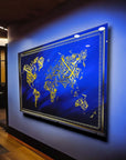 Modern Islamic World Map Glass Art on a blue wall showcasing intricate gold designs.
