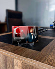 Türk Bayrağı ve tasarımcı figürüyle şık cam tablo, ofis masasında dekoratif bir dokunuş.