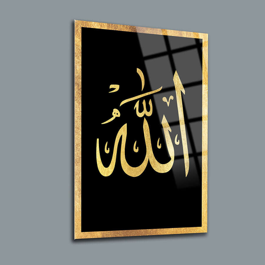 Elegantly designed glass wall art featuring the Arabic calligraphy of 'Allah' in gold on a black background.