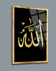 Elegantly designed glass wall art featuring the Arabic calligraphy of 'Allah' in gold on a black background.