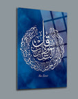 Artistic glass wall panel featuring intricate calligraphy of Felak Nas Surahs on a blue background.