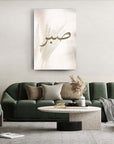Minimalist cam tablo 'Sabır' üzerindeki hafif doğal unsurlarla modern oturma odası dekoru.