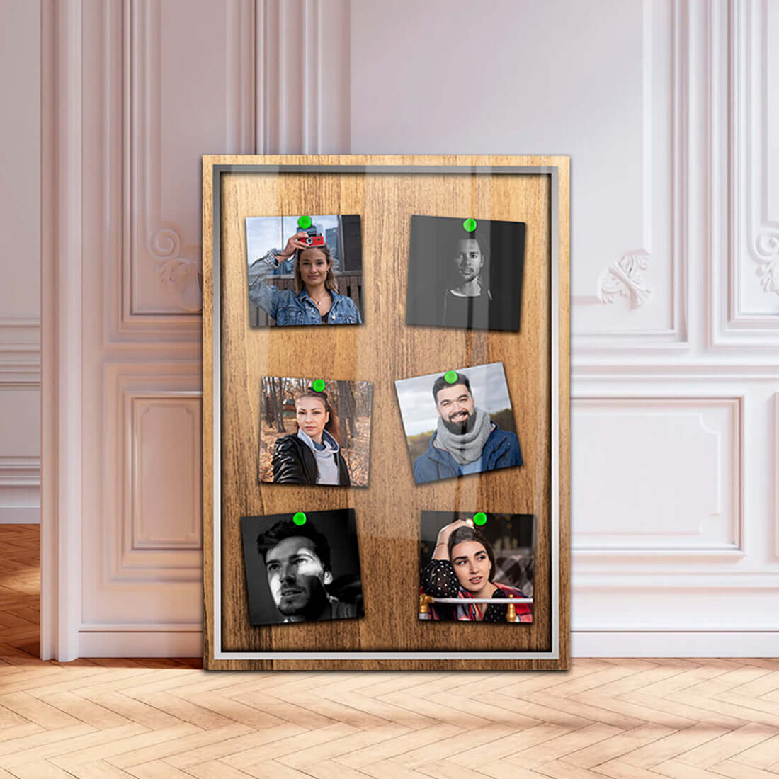 Wooden photo frame displaying six portraits with decorative green pins, set in a stylish interior.