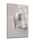 Modern woman figure art sculpture on a clear glass panel with golden ring detail.