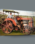 Historical image of a man in a suit on a vintage red tractor in a green field.