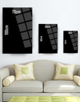 Three framed black wall art sizes displayed above a light sofa with decorative cushions.