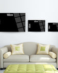 Modern black glass wall art sizes 30cm, 45cm, 65cm, 70cm displayed above a stylish green sofa.