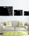Various sizes of SRD Concept glass wall art displayed above a stylish sofa in a modern living room.