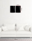 Modern black glass wall art set above a stylish white sofa in a minimalist living room.