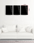 Modern black glass triptych wall art above a white sofa, showcasing sleek design and dimensions.