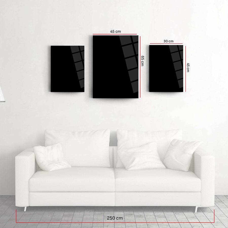 Modern 3-piece black glass art set above a white sofa, showcasing sleek design and dimensions.