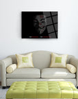 Contemporary art piece featuring a face and text on a black background above a modern sofa.