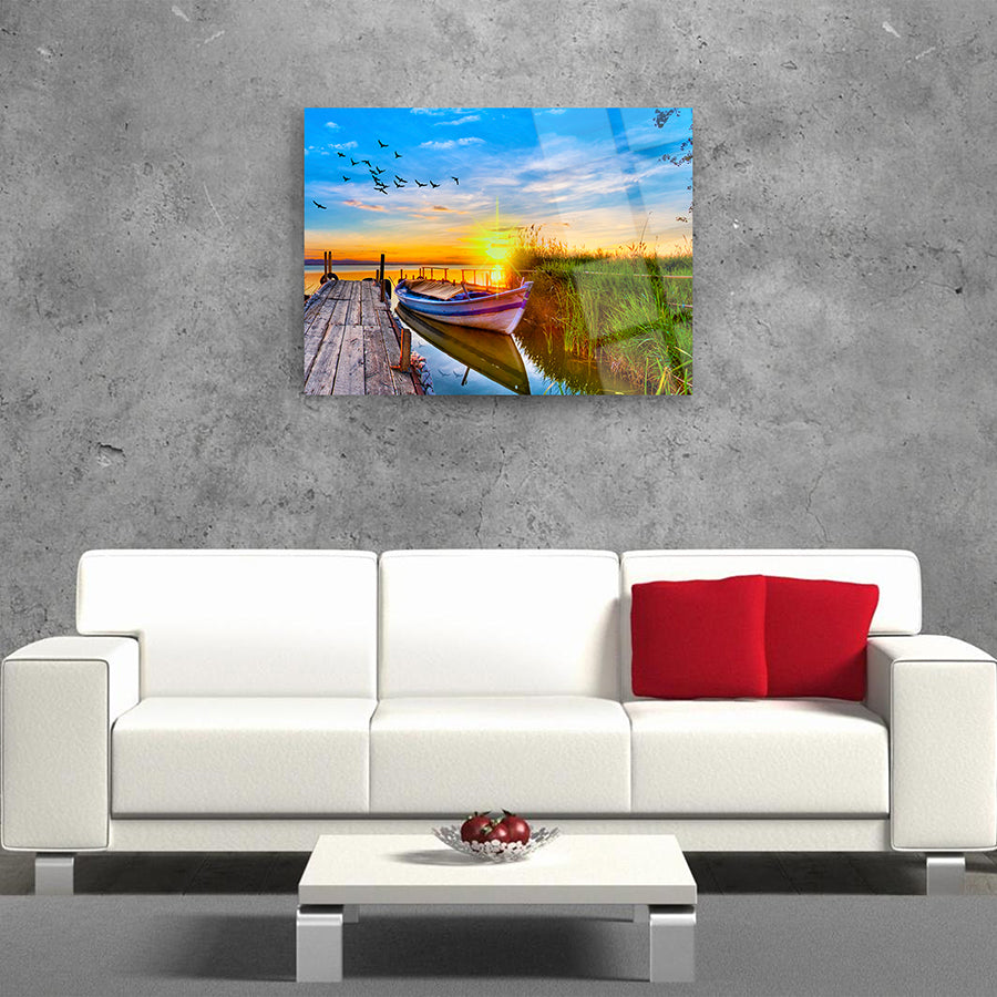Kayık ve günbatımı manzarası, modern oturma odasında cam tablo olarak sergilenmiş.