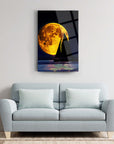 Sailboat silhouette under a full moon, framed on a modern wall-mounted glass artwork.