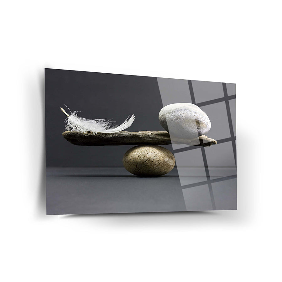 Denge Cam Tablo featuring a feather and stones balanced artistically on a sleek glass surface.