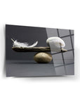 Denge Cam Tablo featuring a feather and stones balanced artistically on a sleek glass surface.