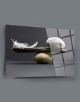 Denge Cam Tablo showcasing a feather and stones with a sleek design on a grey background.