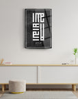 Kufi La İlahe İllallah Cam Tablo in modern living room decor with plant and minimalist furniture.