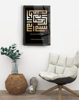 Kufi Bismillahirrahmanirrahim glass art piece displayed in modern room with plant and chair.