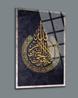 A yet elegant Ayetel Kürsi cam tablo with intricate gold Arabic calligraphy on a dark background.