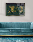 Elegant living room featuring a teal velvet couch and a stylish wall art with Arabic calligraphy.
