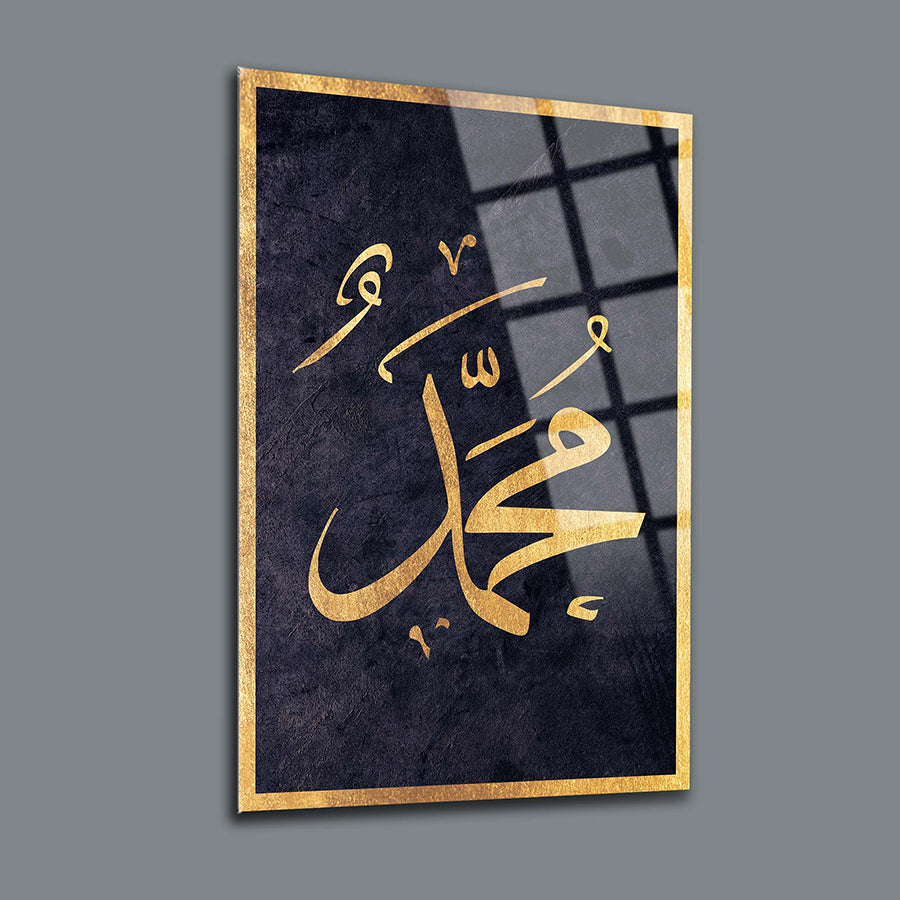 Decorative glass art featuring the name Muhammad in elegant gold script on a dark background.