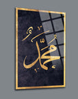 Decorative glass art featuring the name Muhammad in elegant gold script on a dark background.