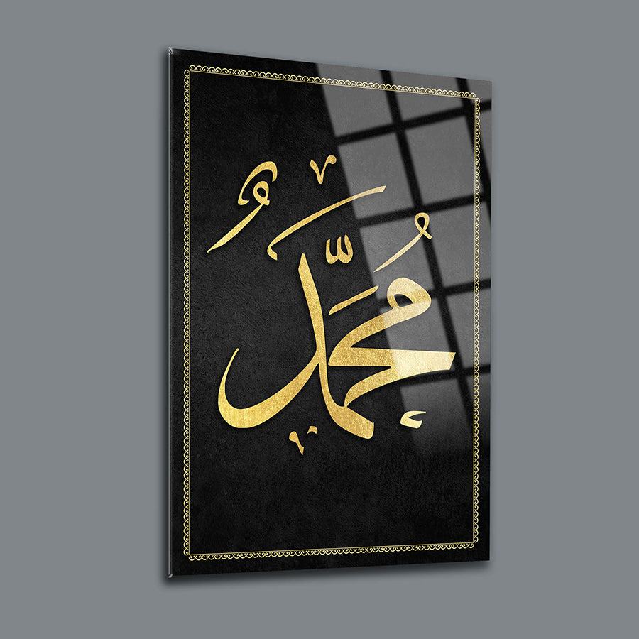 Elegant glass wall art depicting the name Muhammad in golden calligraphy on a black background.