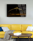 Elegant gold and black glass art piece displayed above a stylish yellow couch in a modern living room.
