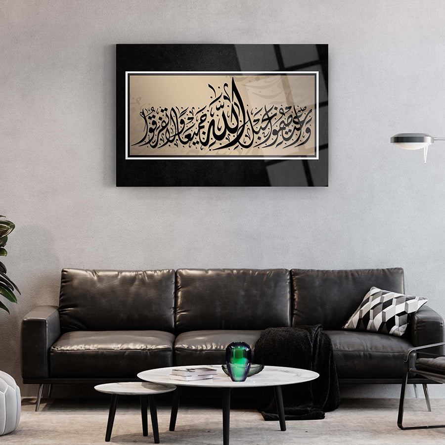 Al-i İmran Suresi Cam Tablo on wall in modern living room with black couch and decorative elements.