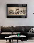 Al-i İmran Suresi Cam Tablo on wall in modern living room with black couch and decorative elements.