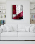 Modern abstract wall art in red and silver hanging above a white sofa in a stylish living room.