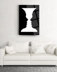 Modern art vase design with two faces in black and white, elegantly displayed above a white sofa.