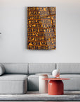 Hieroglyph art glass panel hanging above a modern gray sofa in a stylish living room setting.