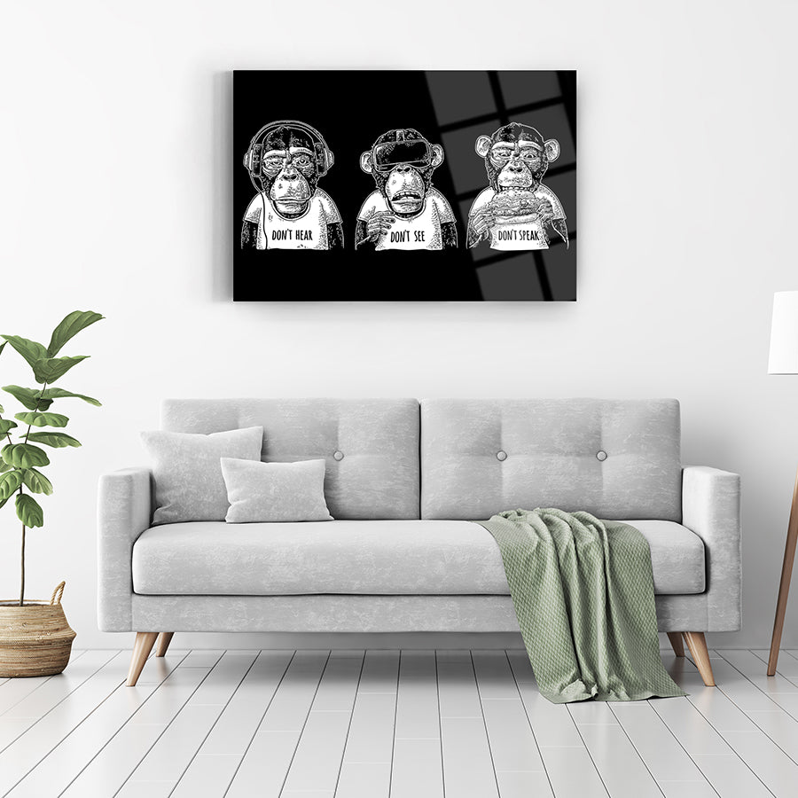 Duyma, görme, konuşma temalı üç maymun resmi, modern oturma odasında cam tablo olarak sergileniyor.