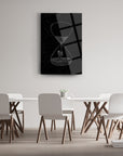 Stylish hourglass artwork on a black glass panel, enhancing modern dining room decor.