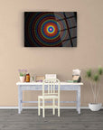 Colorful spiral pattern on a glass wall art piece above a modern desk in a stylish interior.