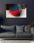 Modern abstract wall art with red and blue design above a stylish gray sofa.