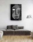 Abstract black and white face artwork on glass, displayed in a modern living room with a sleek design.