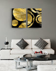 Modern gold and black abstract glass painting set decorating a stylish living room.