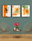 Modern three-panel glass artwork set featuring abstract plant designs on a stylish wall.