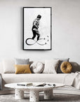 Modern black and white art print depicting a figure walking over an infinity symbol in a stylish living room setting.
