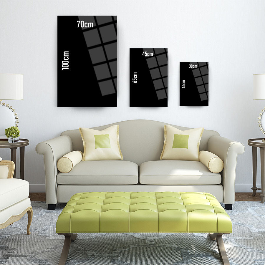 Modern living room featuring three sizes of black wall art: 100cm, 70cm, 45cm, above a stylish green ottoman.