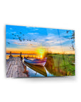 Kayık günbatımı cam tablo, sıcak renklerle dolu doğal manzara ve güzel bir göl kenarı.