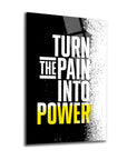 A modern glass artwork featuring the motivational phrase 'Turn the Pain Into Power' in bold lettering.