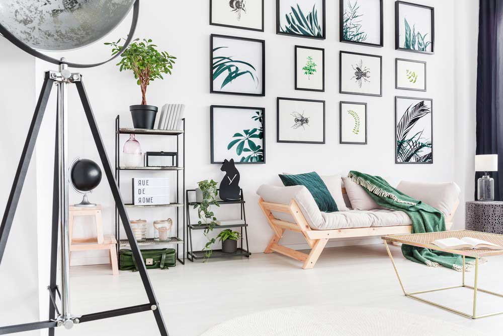 Modern living room featuring botanical wall art, a cozy sofa, and stylish decor elements.