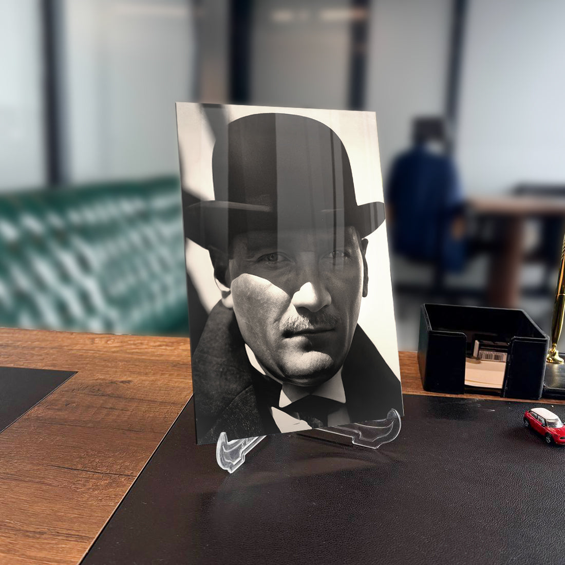 Atatürk 127 Cam Tablo on a desk, featuring a high-quality tempered glass design with a classic black and white photo.